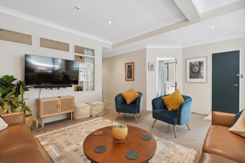 a living room with a couch and chairs and a tv at Spacious, 2 Bed, 2 Bath Central City Retreat in Wellington