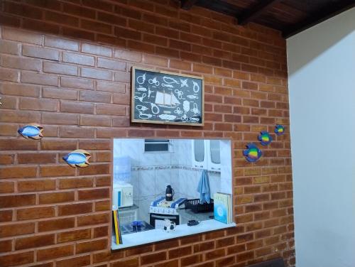 a window in a brick wall with a clock at Casa Duplex de Condomínio no Peró - Cabo Frio in Cabo Frio
