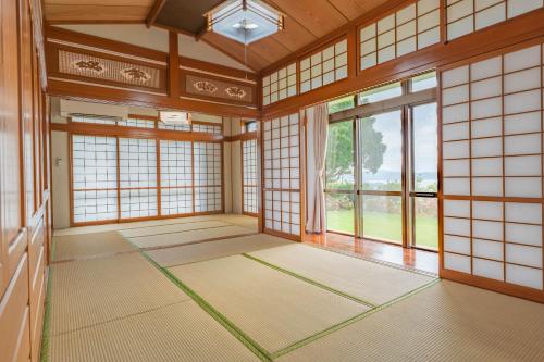 an empty room with a large window in a japanese room at Ocean View House Nakijin in Nakijin