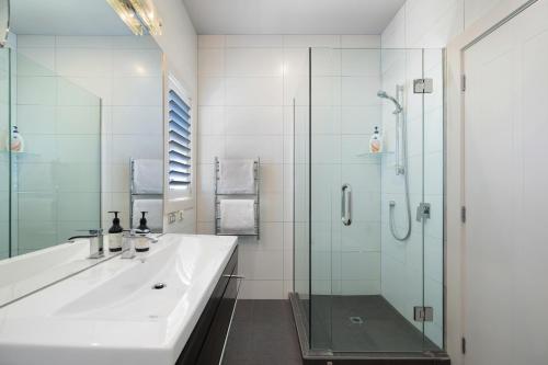 a bathroom with a sink and a glass shower at Arrowtown Home near Golf, Biking & Walking Trails in Motungarara