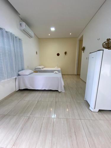 a large room with a bed and a refrigerator at Vila da Andrea 02 in Barreirinhas