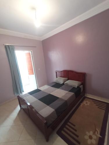 een slaapkamer met een bed en een raam bij Résidence DARNA in Agadir