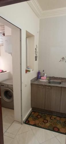 een keuken met een spoelbak en een wasmachine bij Résidence DARNA in Agadir