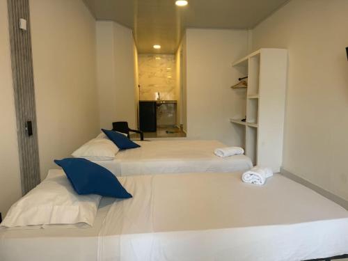 two beds with blue pillows in a room at Casa Fama in San Andrés