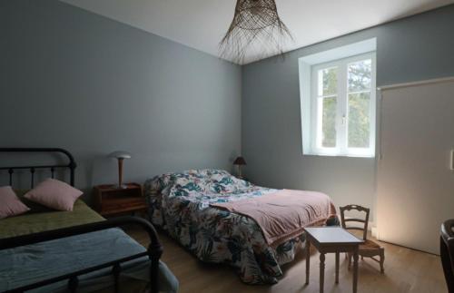 una camera da letto con due letti e una finestra di Le Gentiane - Villa Chanterive a La Bourboule