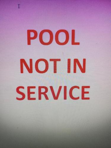 a red sign that sayspool not in service at University Square Hotel in Fresno
