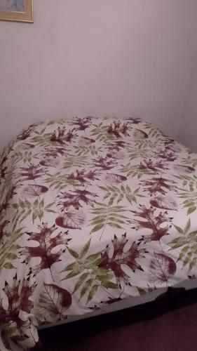 a bed with a floral comforter on top of it at Residencia "Libertad" in San Andrés