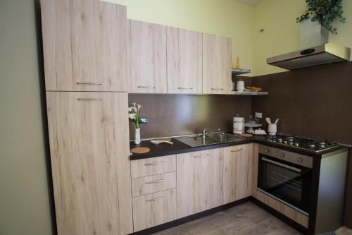 a kitchen with wooden cabinets and a sink and a stove at Casa Vacanze La Mattonara in Viterbo