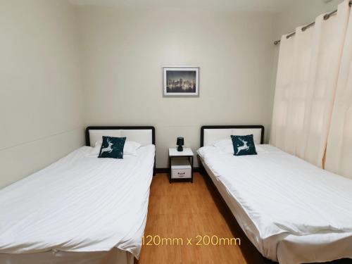 two beds sitting next to each other in a room at NIR Villa in Dumaguete