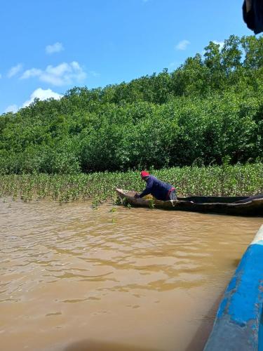 a man sitting on a boat in the water at Wasini house mkwiro village in Shimoni