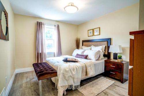een slaapkamer met een bed, een tafel en een raam bij 2 Bedroom East-York bungalow in Toronto