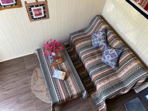 a couch in a corner with a table and flowers at Puluong Mist Valley Home in Pu Luong