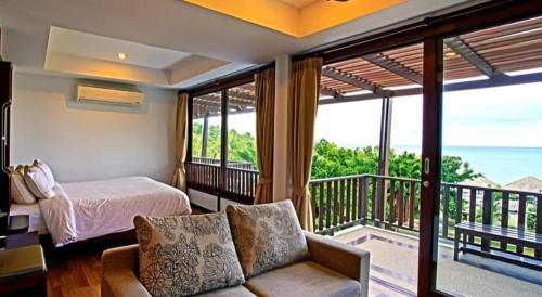 a bedroom with a bed and a balcony with the ocean at Maryoo Samui Hotel in Chaweng