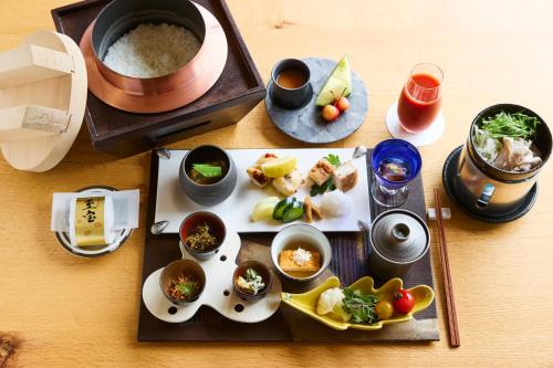 a table with plates of food and bowls of food at Chalet Ivy Jozankei in Jozankei