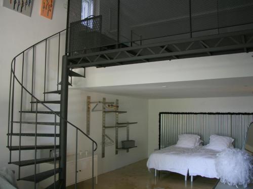 a bedroom with a loft bed and a spiral staircase at Couleur Lavande in Le Thor