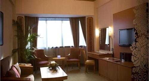 a hotel room with a living area with a television at The CentrePoint Hotel in Bandar Seri Begawan