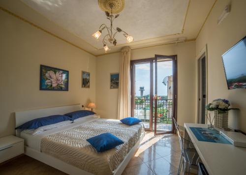 a bedroom with a bed with blue pillows and a window at Airport House B&B in Reggio Calabria