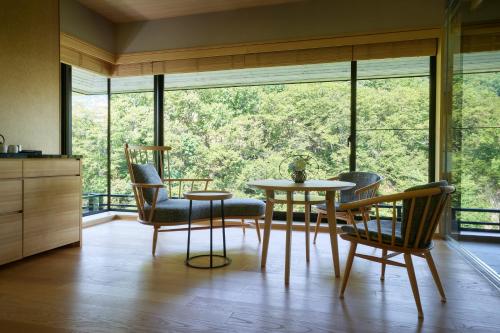a dining room with a table and chairs and a large window at Chalet Ivy Jozankei in Jozankei