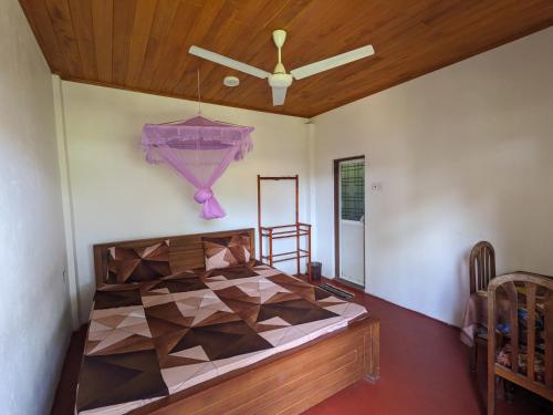 a bedroom with a bed and a ceiling fan at Tropical Point Inn in Matara