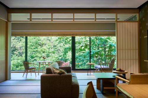 a living room with a couch and a large window at Chalet Ivy Jozankei in Jozankei