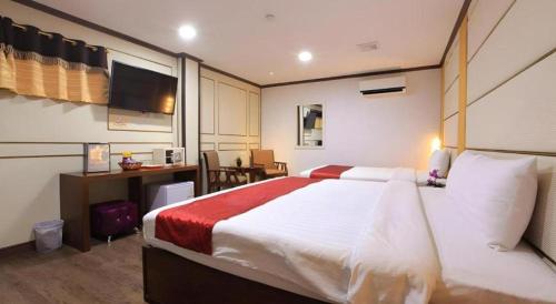 a hotel room with a large bed and a desk at Horizon Hotel in Olongapo