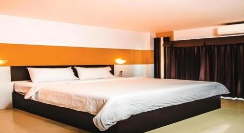 a bedroom with a large bed with white sheets at Mukdaview Hotel in Mukdahan