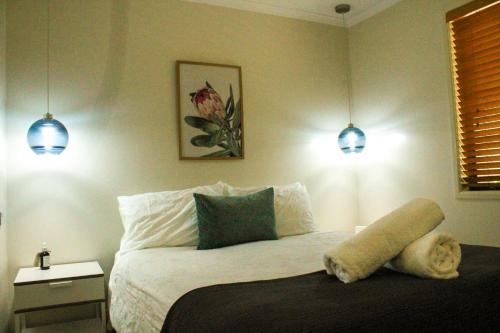a bedroom with a bed with two lights on it at 31 The Rocks in Stanthorpe