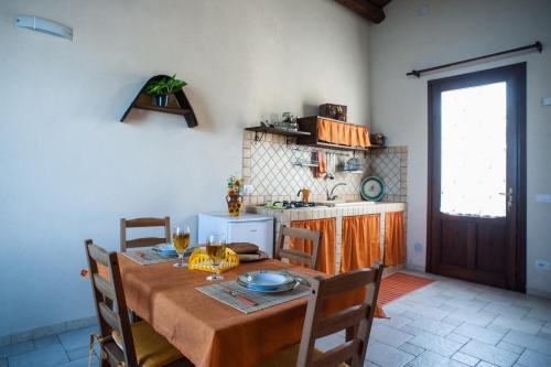 a kitchen with a wooden table with chairs and a dining room at I 5 SENSI in Marina di Modica