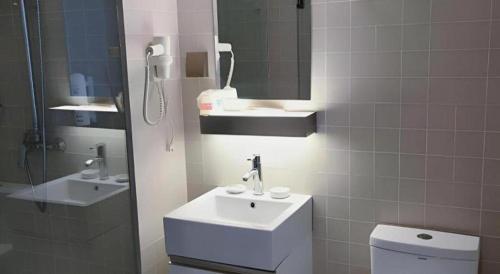 a bathroom with a sink and a toilet and a mirror at Jinjiang Inn Select Xuzhou High-speed Railway Station Kunpeng Road in Xuzhou