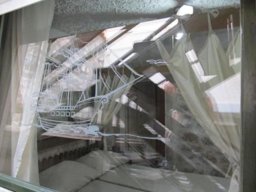 a reflection of a man in a window with a boat at Fischer Fritz 2 in Betina