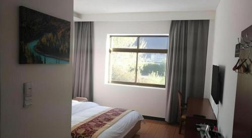 a hotel room with a bed and a window at Shell Linzhi Bayi Area G318 Shuangyong Road Hotel in Nyingchi