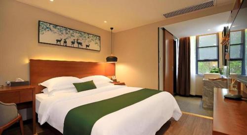 a hotel room with a large bed and a desk at Immersing Hotel Guilin Two Rivers and Four Lakes Dongxi Alley in Guilin