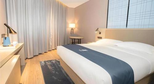 a bedroom with a large bed and a large window at Echarm Hotel Changde Taoyuan Walking Street Jinyuan Tower in Changde