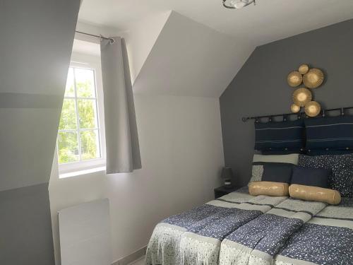 une chambre avec un lit bleu et une fenêtre dans l'établissement Appartement 2 chambres et cuisine-salon Plages du Débarquement, à Vierville-sur-Mer