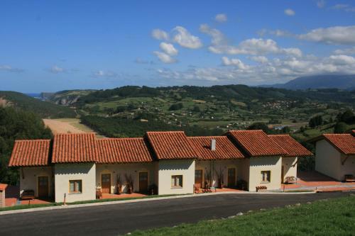 una fila de casas con techos rojos en una carretera en Apartamentos Monterodiles, en Liñero