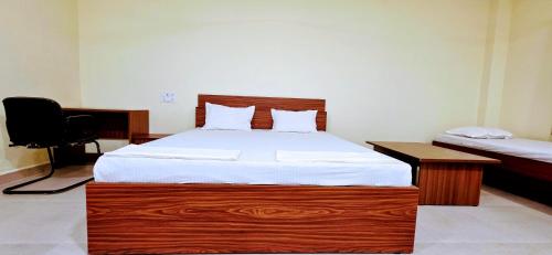 Un dormitorio con una cama grande con cabecero de madera. en Aathidya Lodge, en Ādoni