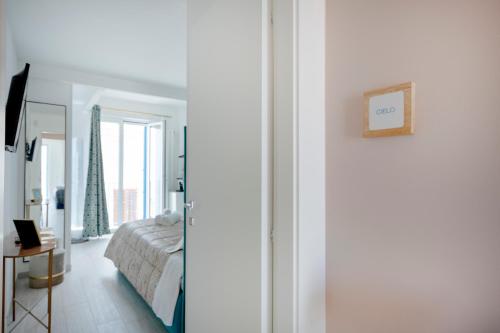 a bedroom with a bed and a room with a window at Altamarea Rooms - Luxury Seaview Suites in Polignano a Mare