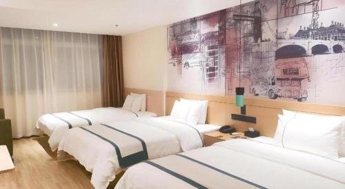 a hotel room with two beds and a painting on the wall at City Comfort Inn Lichuan Railway Station Jimi Home in Enshi