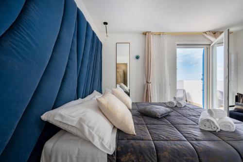 a blue bedroom with a bed with towels on it at Altamarea Rooms - Luxury Seaview Suites in Polignano a Mare