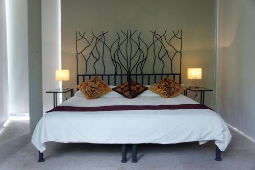 - une chambre avec un grand lit blanc et des oreillers dans l'établissement Casa Tepoztlán, à Tepoztlán