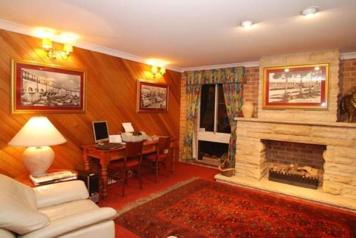 a living room filled with furniture and a fireplace at The Hermitage Motel - Campbelltown in Campbelltown