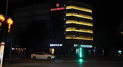 a white car parked in front of a building at night at City 118 Selected Hotel Xi'an Fengcheng Nan Road in Xi'an