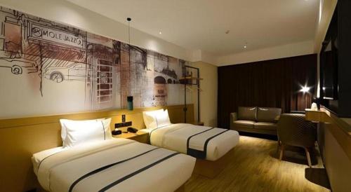 a hotel room with two beds and a couch at City Comfort Inn Shiyan Wudang Mountain in Danjiangkou