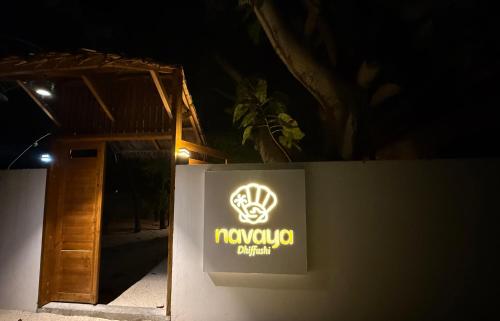 a sign on a wall next to a door at Navaya Dhiffushi in Dhiffushi