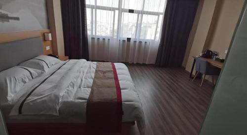 a large bed in a hotel room with a window at Thank Inn Hotel Jiangsu Wuxi High-Tech Zone Ruigang Pedestrian Street in Wuxi