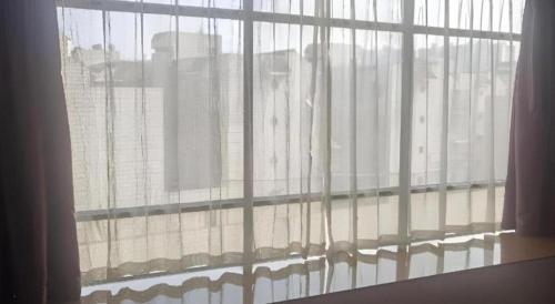 an open window with a view of a building at Borrman Hotel Liuzhou High-Speed Railway Station in Liuzhou