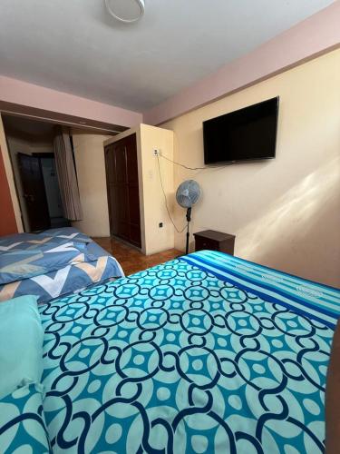 チクラーヨにあるHostal Muchikのベッド2台と薄型テレビ付きのベッドルーム