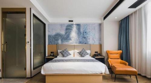 a bedroom with a large bed and a chair at GEM Hotel Changzhou Xuejia'aoyuan North High-Speed Railway Station in Changzhou