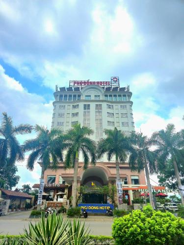 a large building with palm trees in front of it at Phù Đổng Hotel in Thanh Hóa