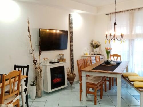 a kitchen and dining room with a table and a fireplace at Kőszeghegyalja Vendégház in Horvátzsidány